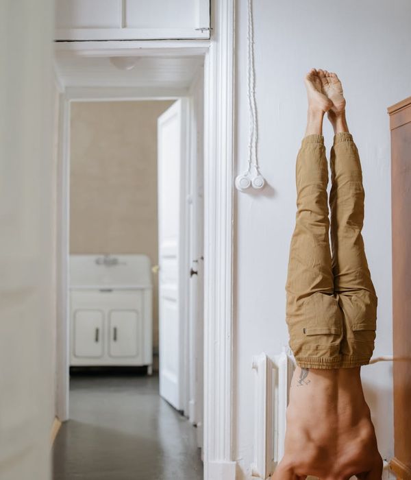 Man performing a controlled strength exercise in a minimalist dark room.